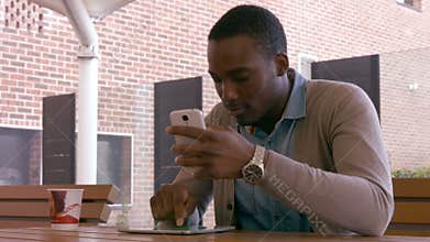 Sitting young man using smartphone and tablet