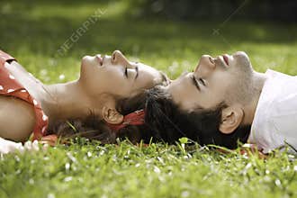 Couple in love lying on the grass in the park