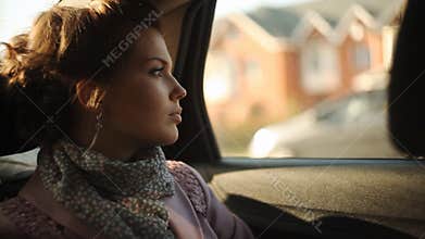 Sad woman in a taxi and looking out the window