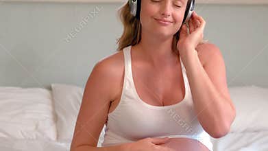 Pregnant woman with headphones