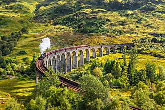 Glenfinnan Railway Viaduct in Scotland with a steam train