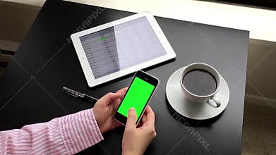 Woman holding a green screen iphone