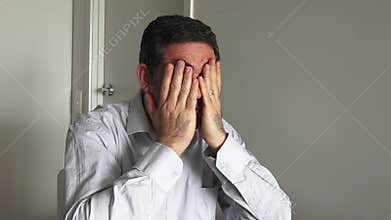 Man in his forties (40s) sitting at a table upset