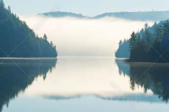 Reflection of Morning Fog Rising on Lake