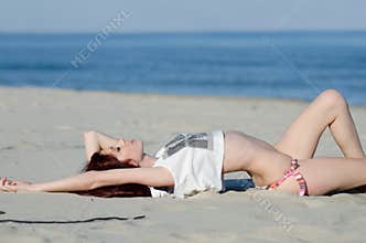 Slim young red hair woman wearing bottom bikini and shirt