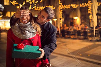 Man keeps his girlfriend eyes covered while she giving a gift
