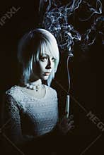 Teen girl in the dark with a candle, fear on her