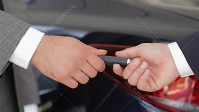 Salesman giving the key of the new car