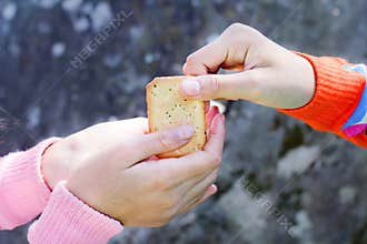 Sharing food. Women giving a cracker to a small child. Charity c