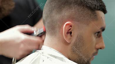 Bearded brutal man in a barber shop