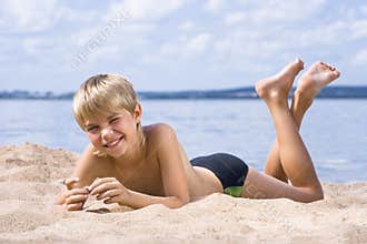 Boy in sand on seashore