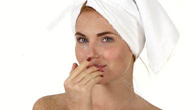 Woman applying cream on face. Close up, bathroom