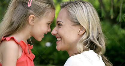 Portrait of cute mother and daughter embracing and smiling