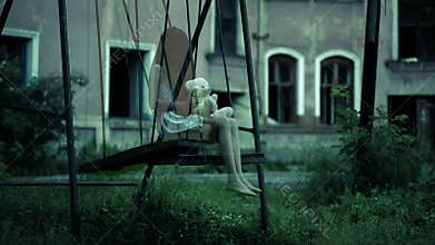 The ghost of a little girl on a swing in the old ruined house. evil spirit