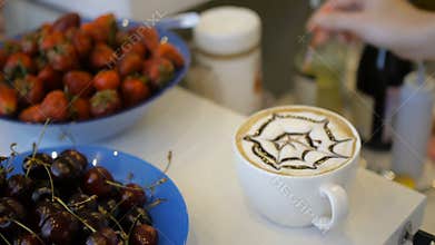 Barista draws chocolate art coffee latte on white cup