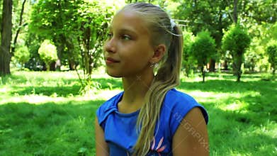 Young teenage girl in a park drinking water