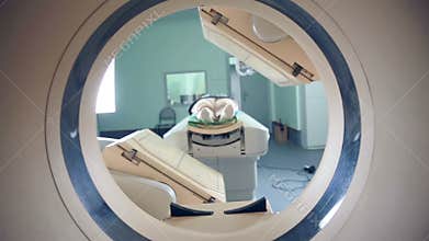 Unrecognizable hospital patient lying on MRI, tomograph, scanner, moving to and from the camera. Slider shoot.