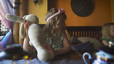 Two cute little blondies are playing in a cafe