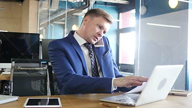 businessman doing multitasking , working with documents , laptop and phone