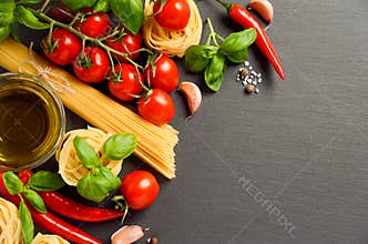 Pasta, vegetables, herbs and spices for Italian food on black background