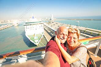 Senior happy couple taking selfie on ship at Barcelona harbour