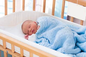 Newborn baby boy in hospital cot