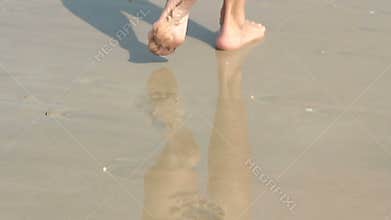 Girl walking on sand beach leaving footprints