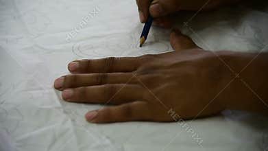 Drawing the patterns on the textile for batik