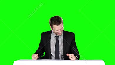 Happy businessman sitting at the table. Green screen