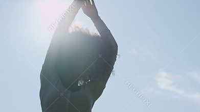 Young afro american woman relaxing in park with a sunset behind her.