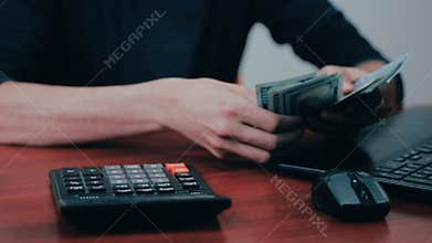 A man with calculator and bills counting money. Finances, business, economy.