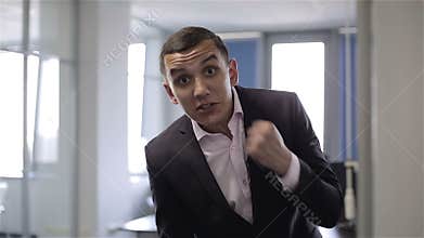 Young aggressive man looking into the camera, saying and showing a fist.