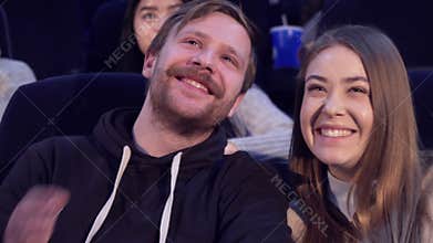 Man whisper something to his girlfriend at the movie theater