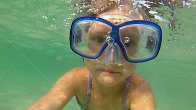 Girl swimming underwater wearing a mask