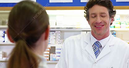 Pharmacist giving pill bottle to customer
