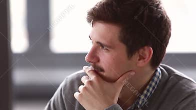 Profile of young businessman talking in meeting