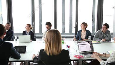 Business people sitting at table in conference room and listening presentation