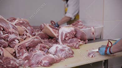 Food industry, meat processing. Butchers Cutting Pork Meat at a Meat Factory.