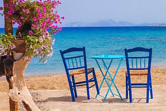 Restaurant table and chairs with a relaxing view of Moutsouna beach, Naxos island