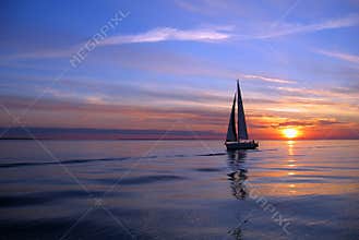 Yacht sailing at sunset