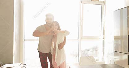 Young Mixed Race Couple Apartment Big Window Morning Sunlight, Cute Happy Hispanic Man And Asian Woman Embracing