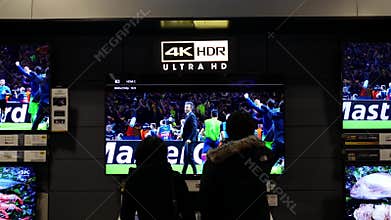 Motion of people looking new tv inside Best buy store
