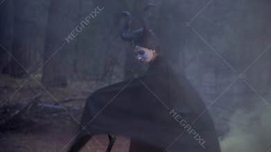 The girl in the image of Maleficent disperses smoke cloak