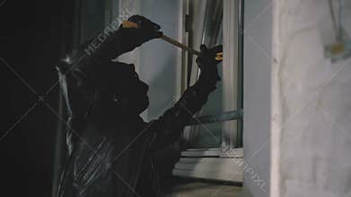 Burglar with crowbar break door to enter the house