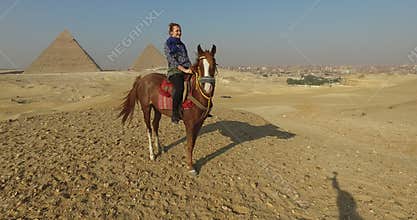 Happy woman on horseback at Giza pyramids complex