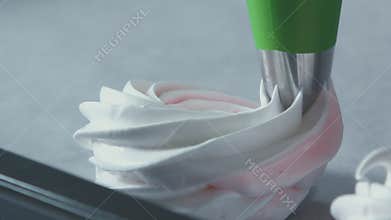 Pastry tube spread meringue on a baking sheet. Cookie press.