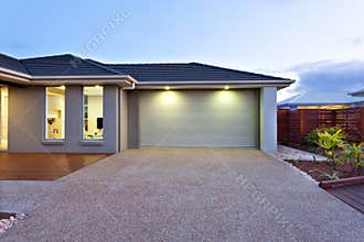 Garage with a long and wide concrete or stone yard in front at d