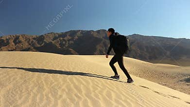 woman climbing a sand dune