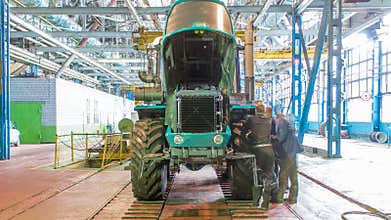 Conveyor assembly stage the body of tractor at factory timelapse