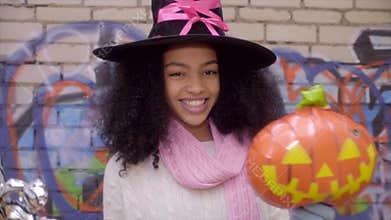 Cute black teen girl in witch hat posing faces on Halloween